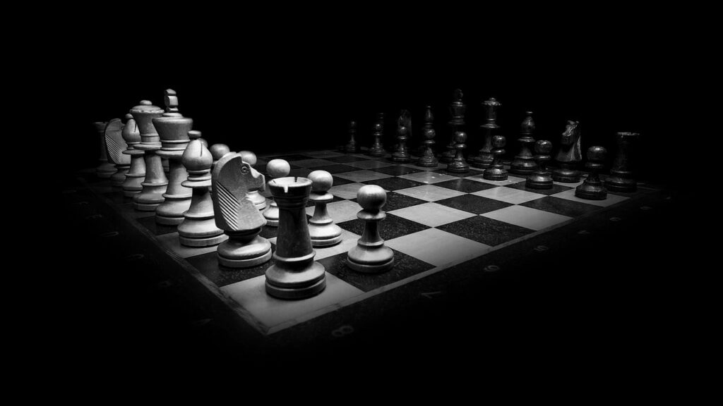 black and white chess pieces and board on a black background