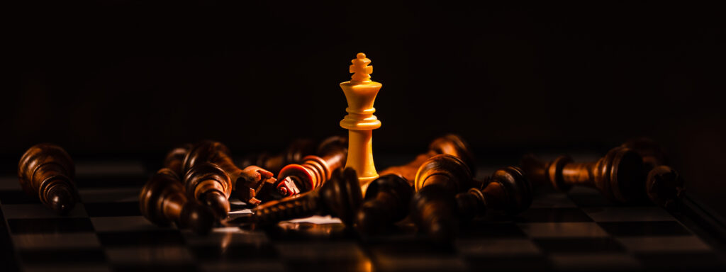 Chess pieces fallen with king still standing