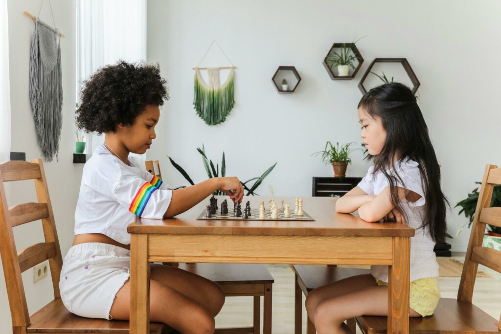 two children practicing chess at home