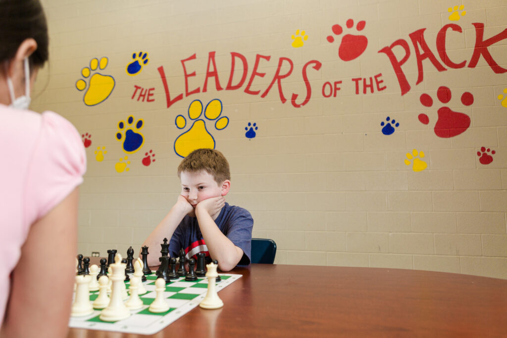 A child playing chess deep in thought