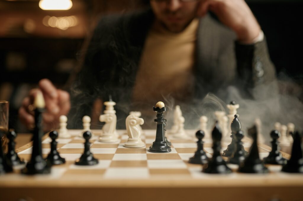 Close-up of a chessboard during an intense game with a player in the background