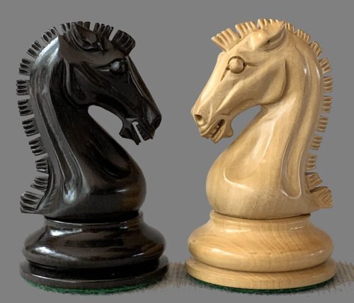 A close-up of two knight chess pieces from the 2023 Sinquefield Cup Player's Edition set, one black and one natural wood